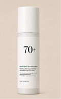 Four Anua skincare bottles and tubes arranged on a warm beige background: a cleansing oil bottle with a pump, a green cleansing foam tube, a clear bottle labeled 77+ with white cap, and a white bottle labeled 70+ with white cap.